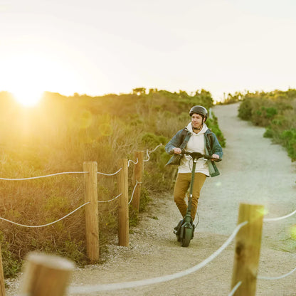 a person riding his segway ninebot p65a during sunset